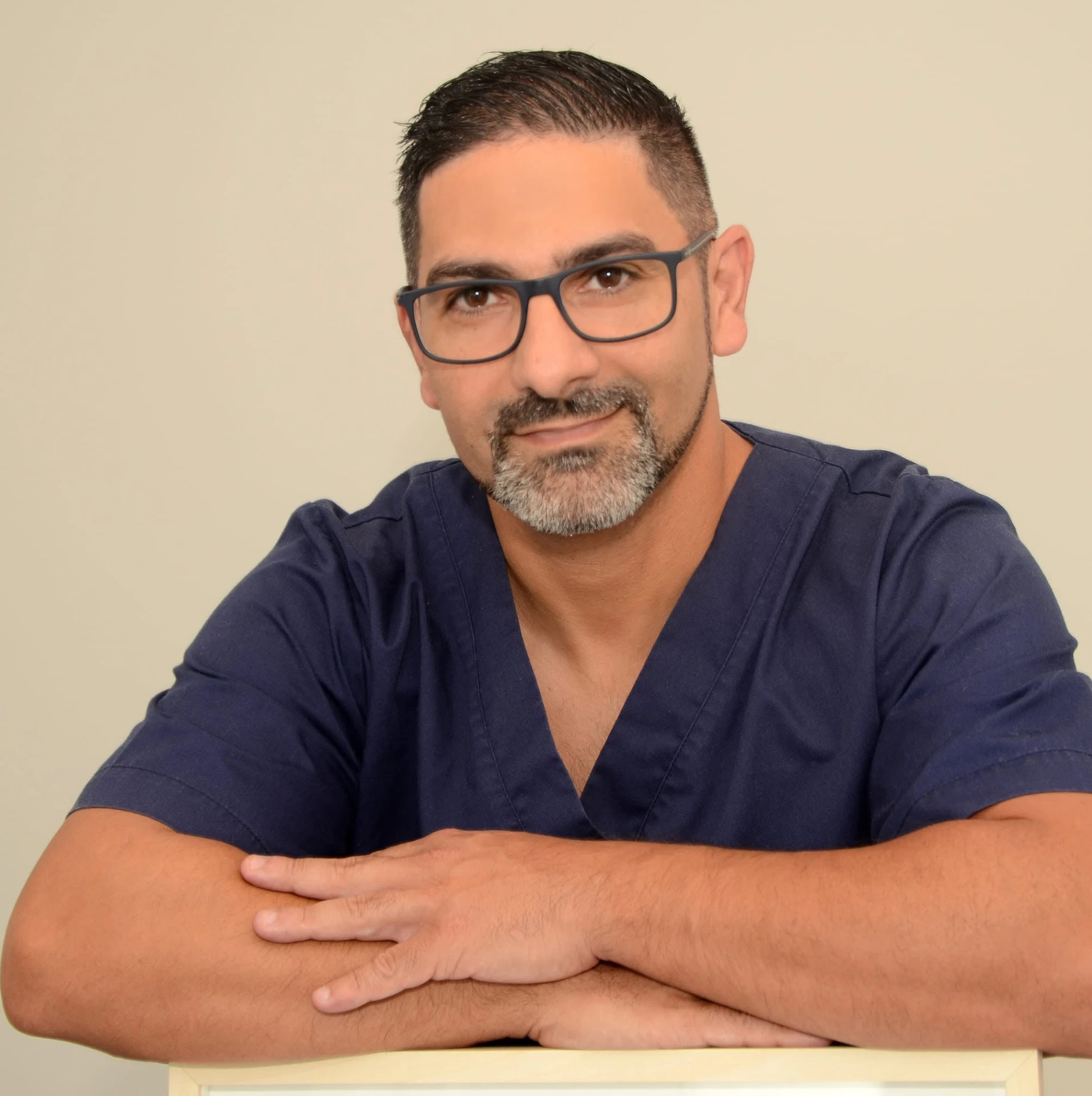 João Machado, osteopata, de braços cruzados em consultório